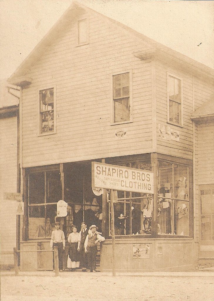 Historic Shapiro Brothers clothing storefront with adults and children at the entrance