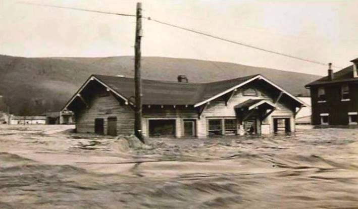 Fast-moving floodwater surrounding a low Mount Union building in 1936