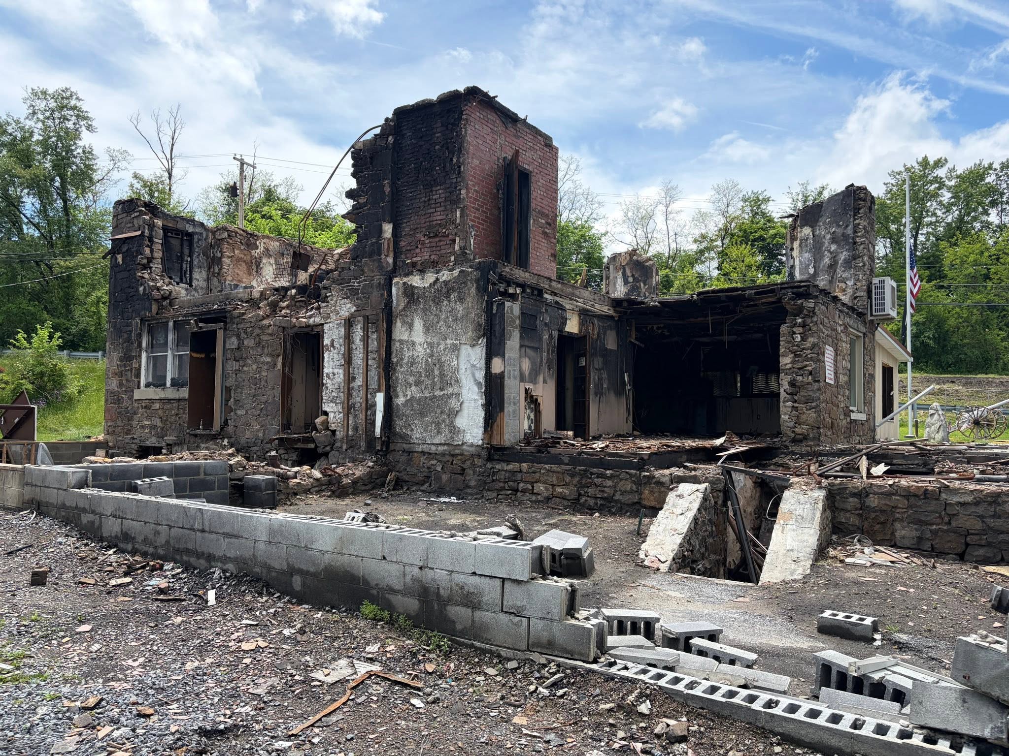 The fire-damaged Stone House after removal of the roof and upper portions, revealing surviving stone walls and interior masonry