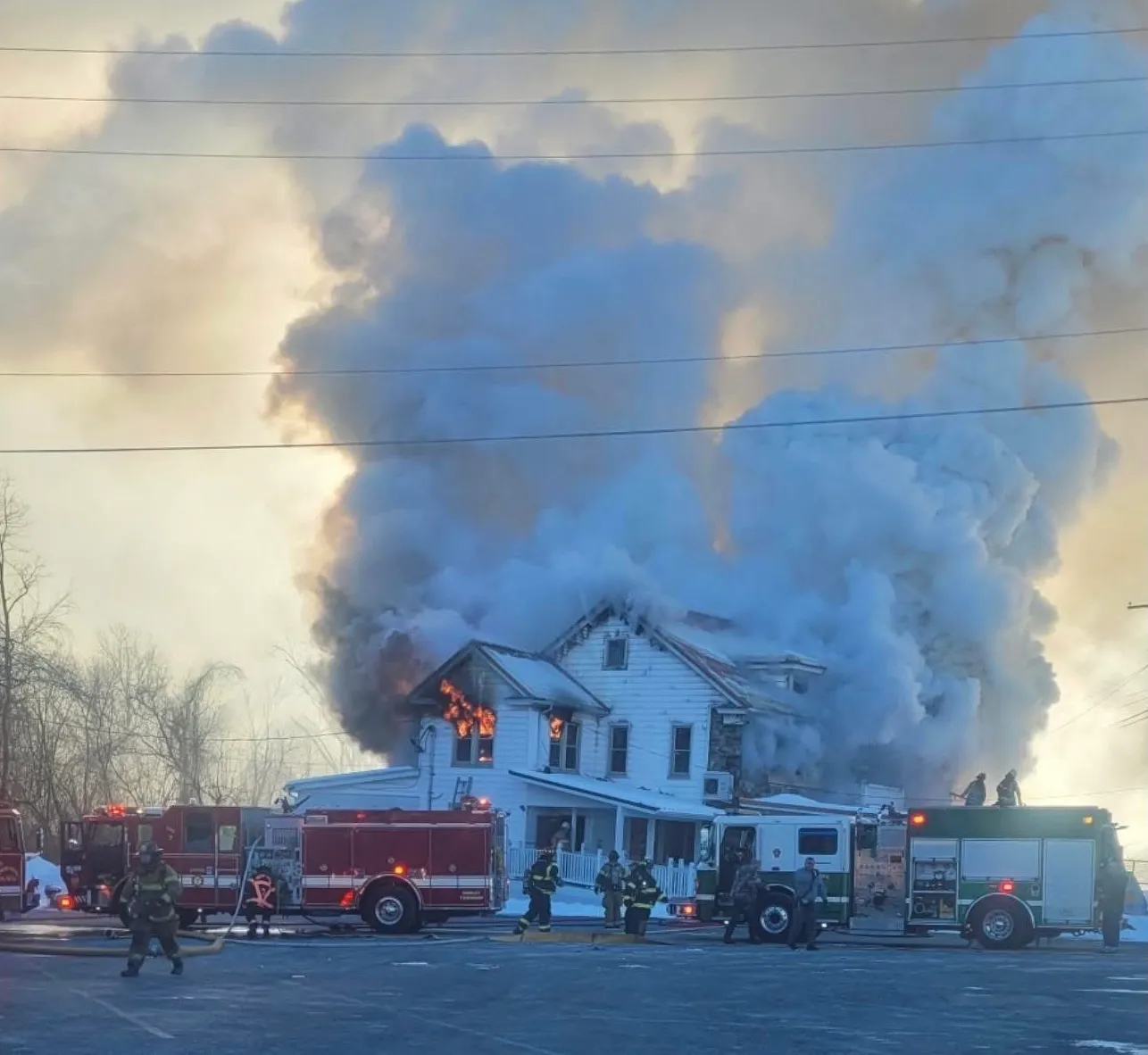 Firefighters and fire engines responding as flames and heavy smoke engulf the Stone House in January 2026
