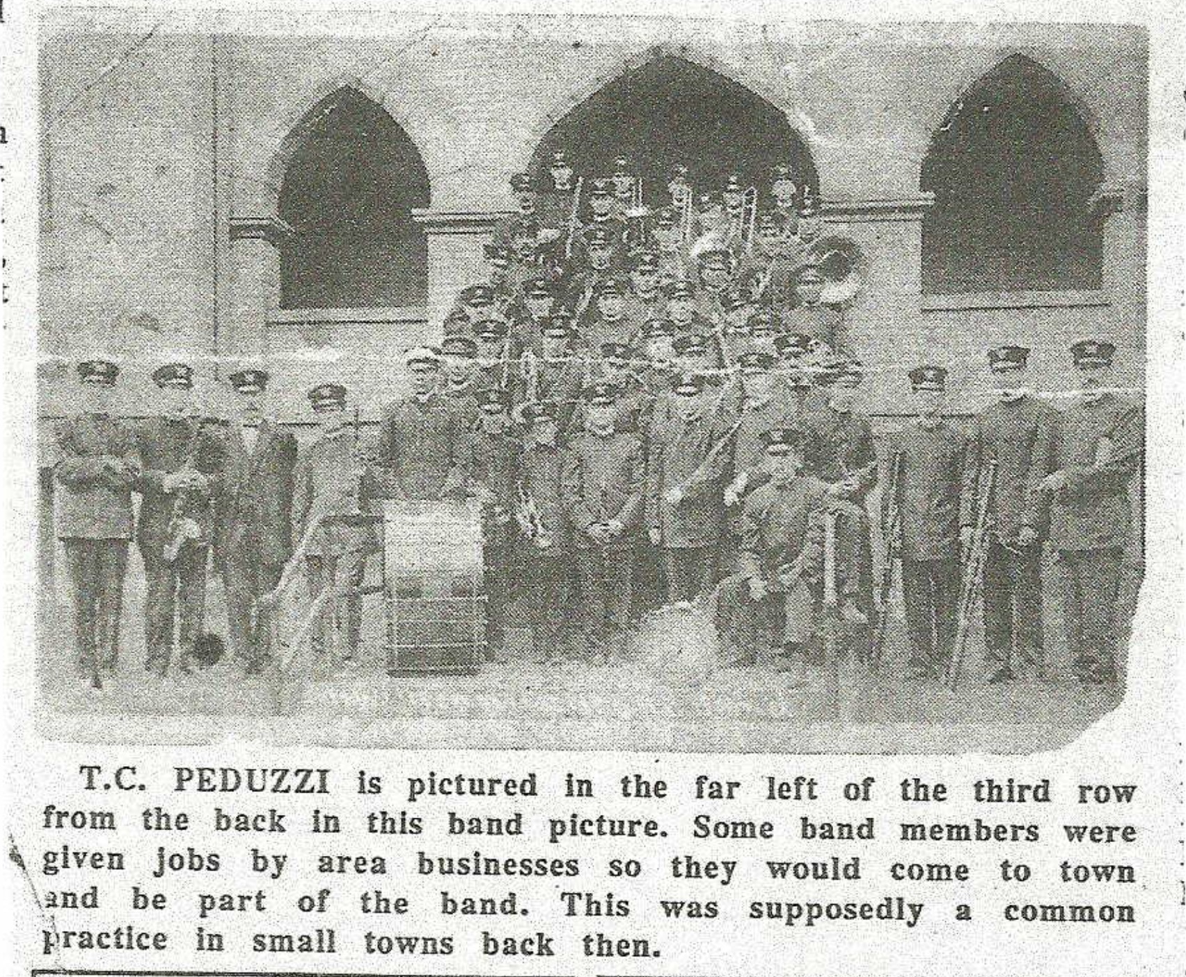 Uniformed band posed with instruments and a caption identifying T.C. Peduzzi