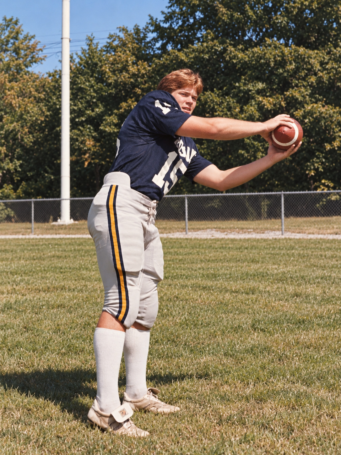 Brian Lewis poses with a football in his Mount Union No. 15 uniform